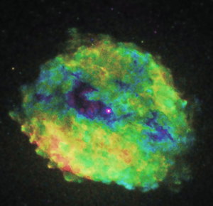 [Thumbnail image: Similar to Figure 14, this shows a circular SNR remnant with rainbow color scheme. There is a "shadow" around the center bright pulsar which is purple, the shadow is darker blues and purples. Most of the rest is yellow and green and clumpy in nature. There is a splotch of red clumpy emission on the bottom left.]